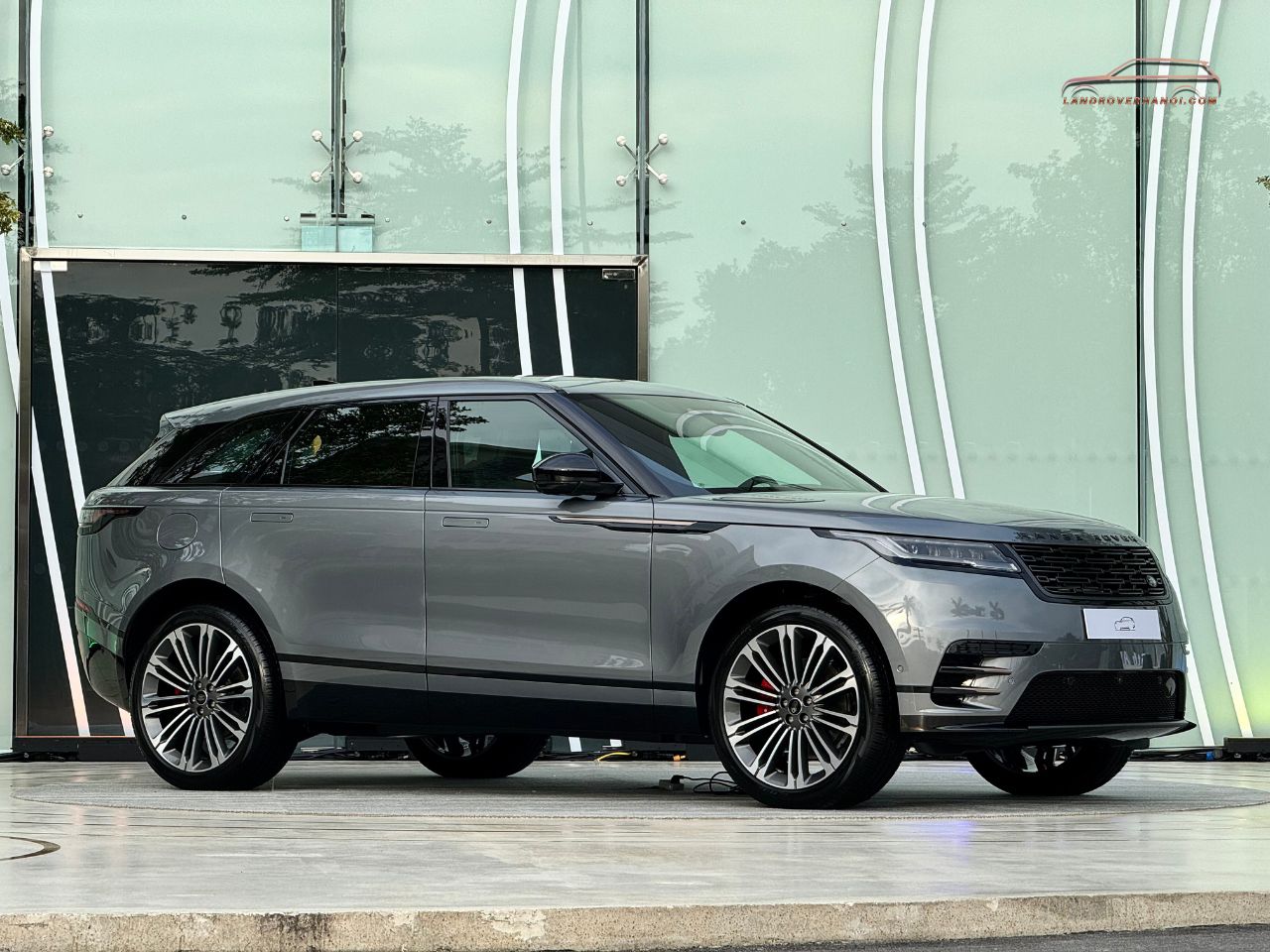 Ngoại thất góc 3/4 bên trái phía trước Range Rover Velar 2026 màu Zadar Grey đỗ tại showroom