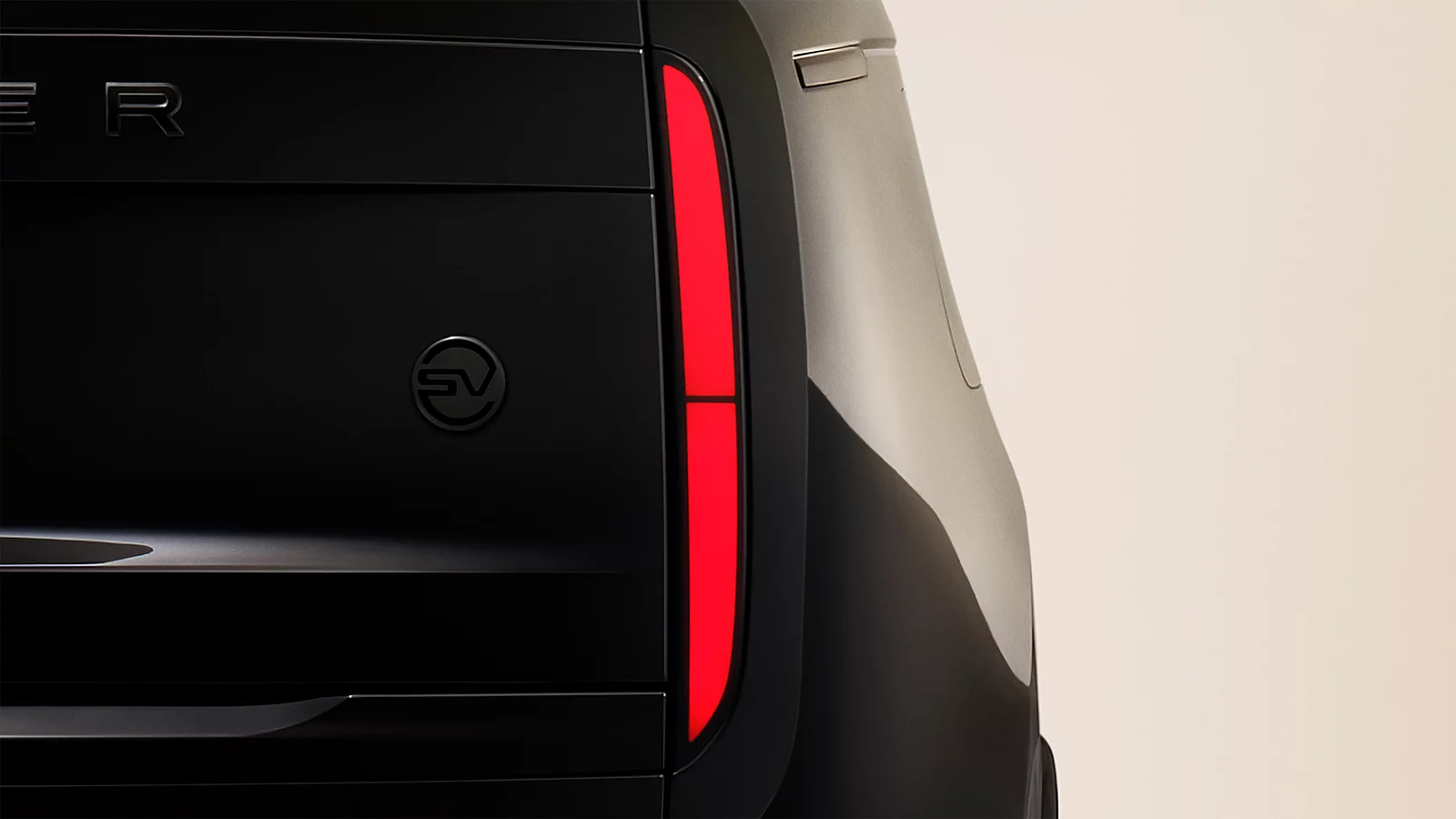 Chi tiết logo SV bằng gốm đen mờ và cụm đèn hậu thanh mảnh của Range Rover SV Black.
